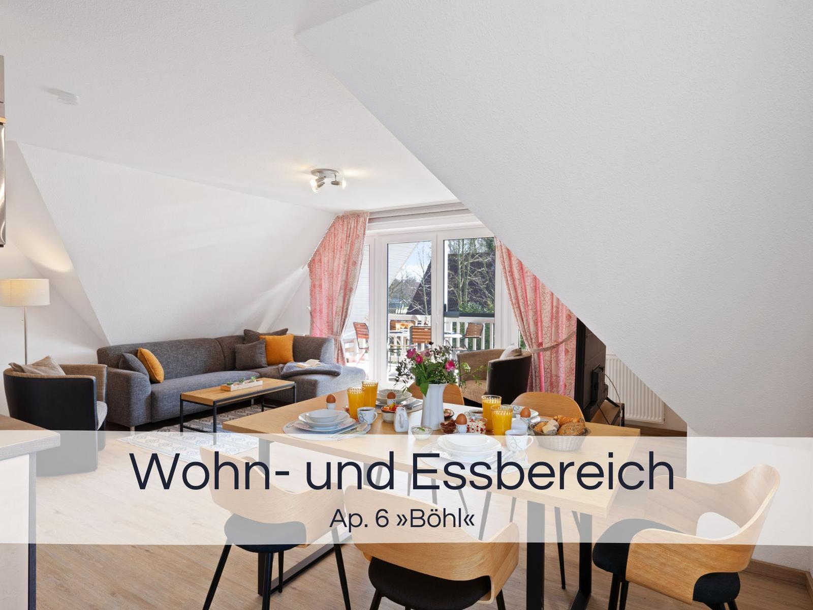 Wohn- und Essbereich mit Sofa, Tisch und Stühlen. Fenster mit rosa Vorhängen.