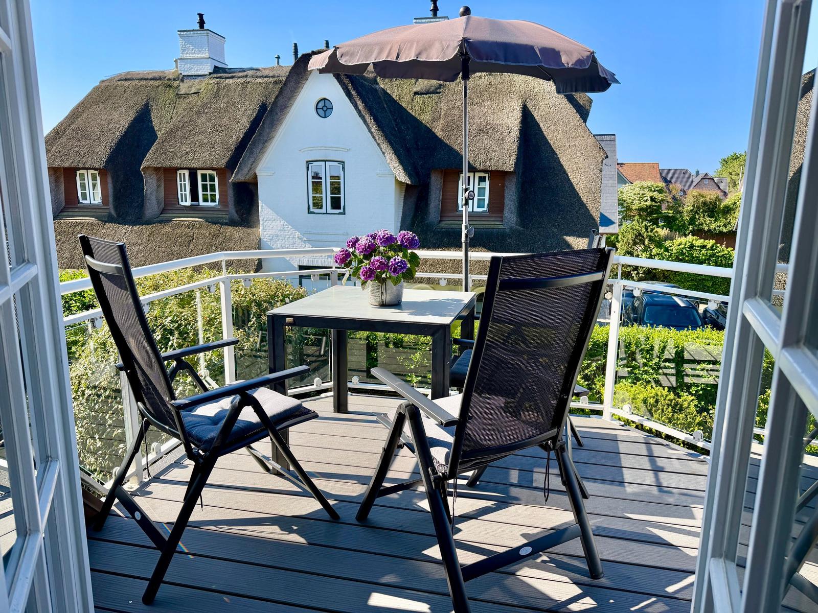 Auf dem schön gestalteten Sonnen-Balkon laden moderne Gartenmöbel zum Verweilen ein.