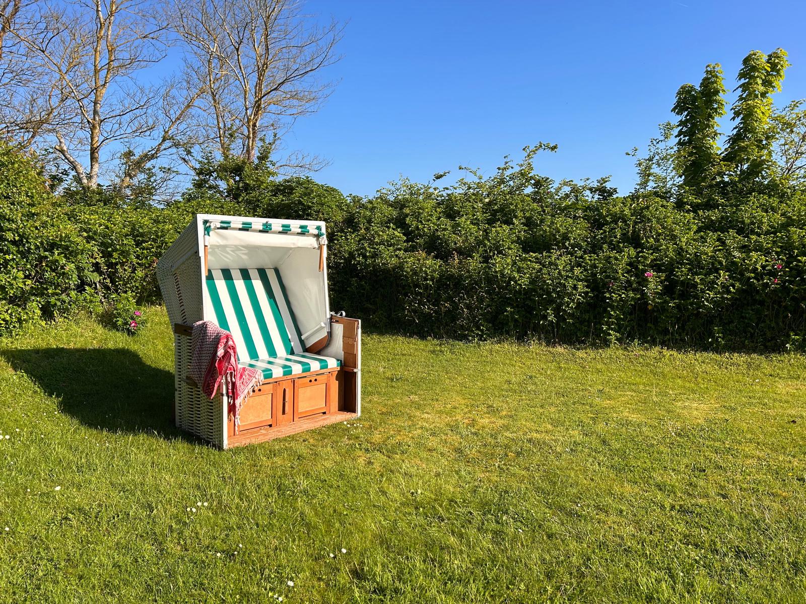 Unser Strandkorb seitlich des Hauses lädt zu gemütlichen Stunden in der Sonne ein.