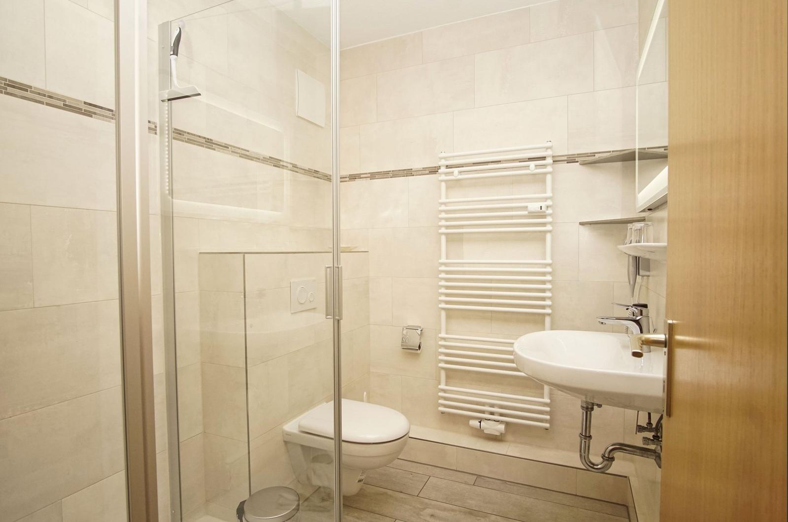 Badezimmer mit Dusche, Toilette und Waschbecken.