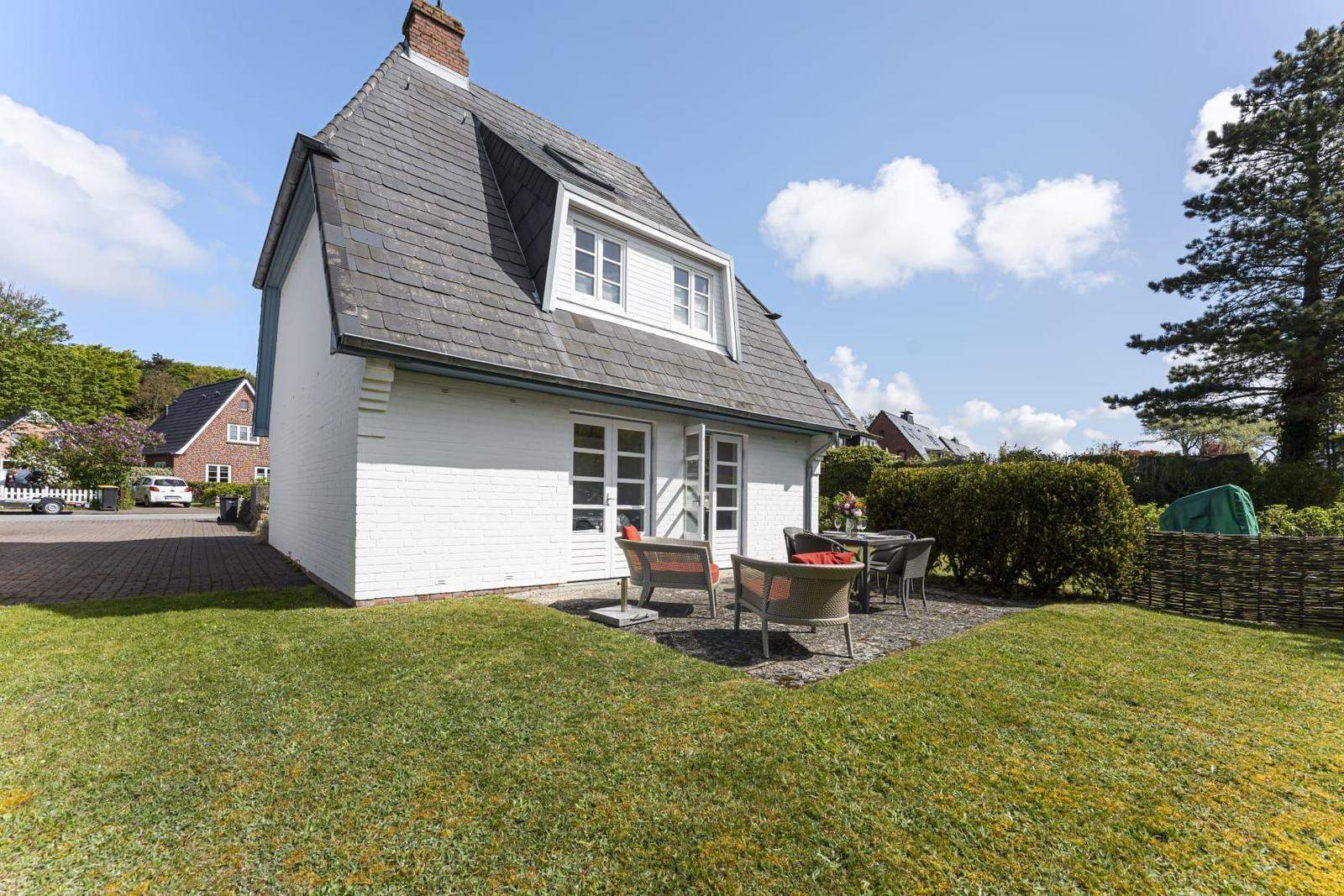 Wohnhaus mit Terrasse, Garten und Grillplatz. Hinterhof mit Hecke und Baum.