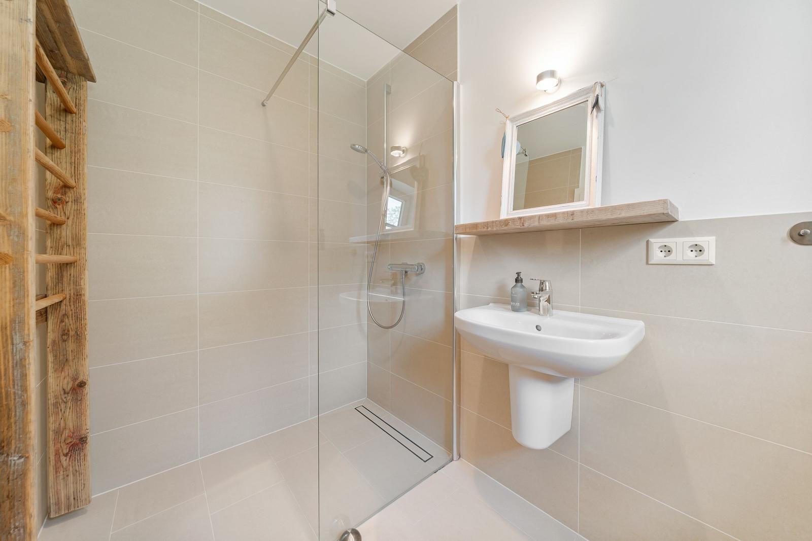 Bad mit Dusche, Waschbecken und Spiegel