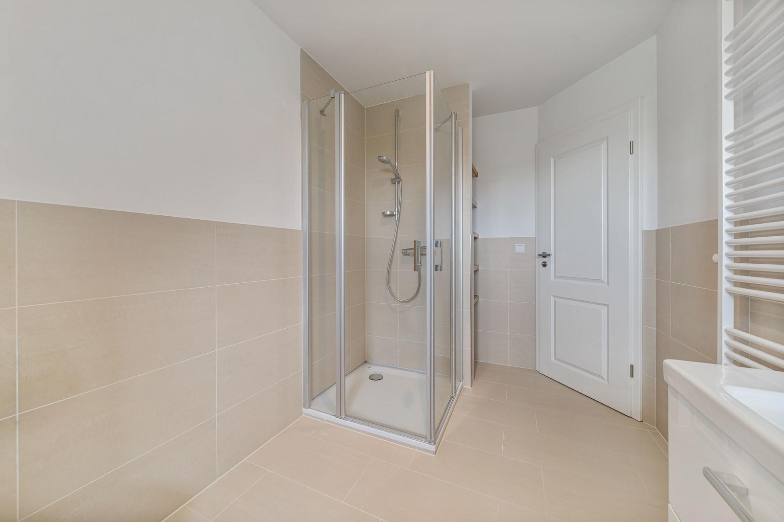 Bad mit Dusche, Waschbecken und Heizkörper