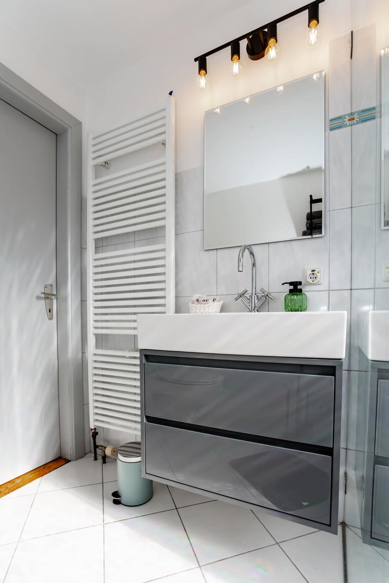 Badezimmer mit Waschbecken, Spiegel und Heizkörper