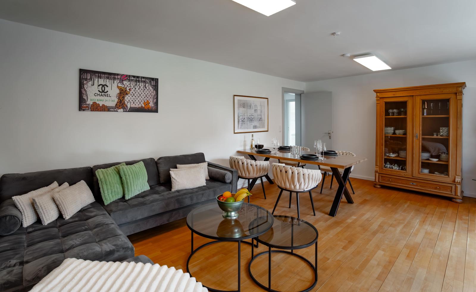 Wohn- und Essbereich mit Sofa, Tisch und Sideboard.