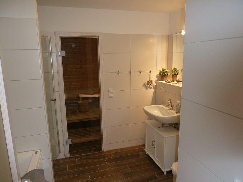 Badezimmer mit Dusche, Waschbecken und Sauna.