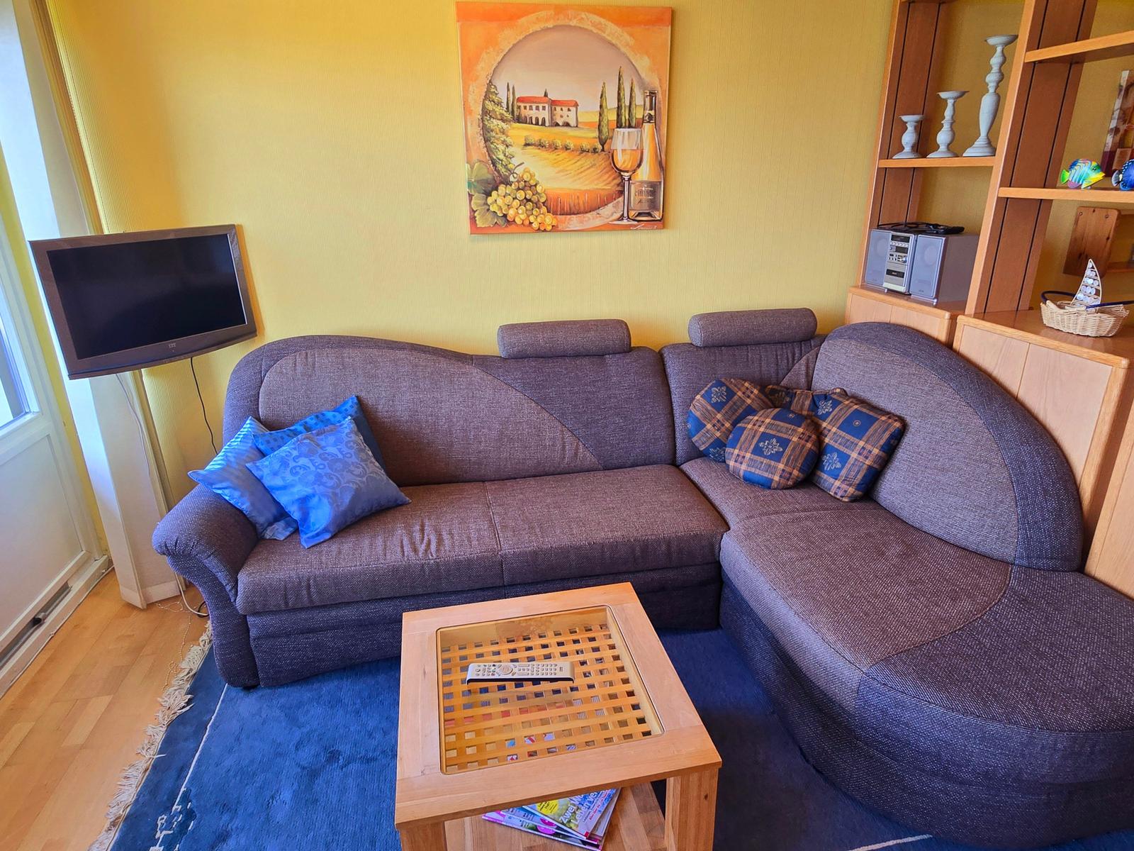 Gemütliches Wohnzimmer mit Sofalandschaft und maritimem Flair für entspannten Ostseeurlaub am Südstrand Fehmarn.