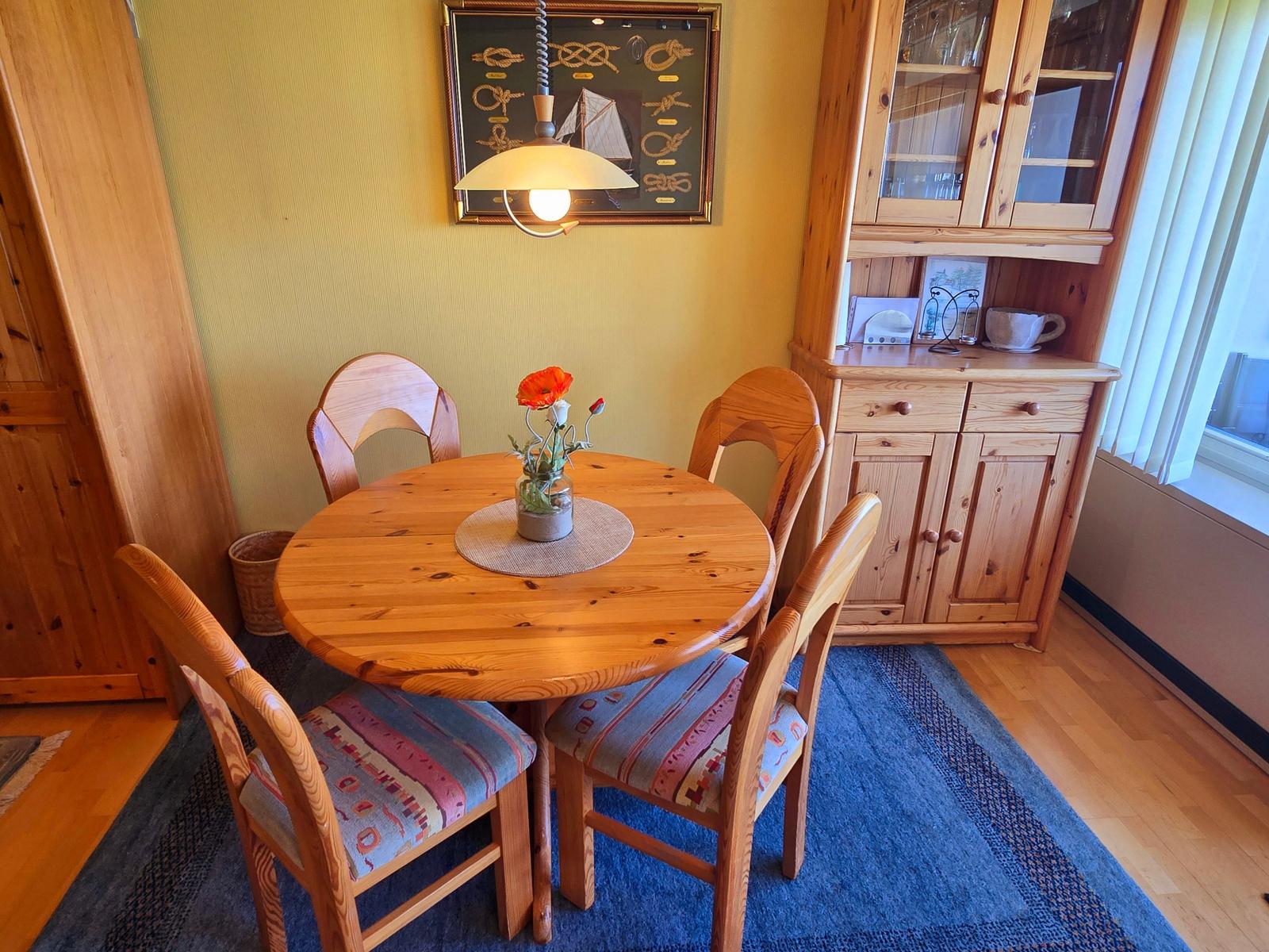 Heller Essbereich mit gemütlicher Sitzecke für gemeinsame Mahlzeiten in strandnaher Ferienwohnung auf Fehmarn.