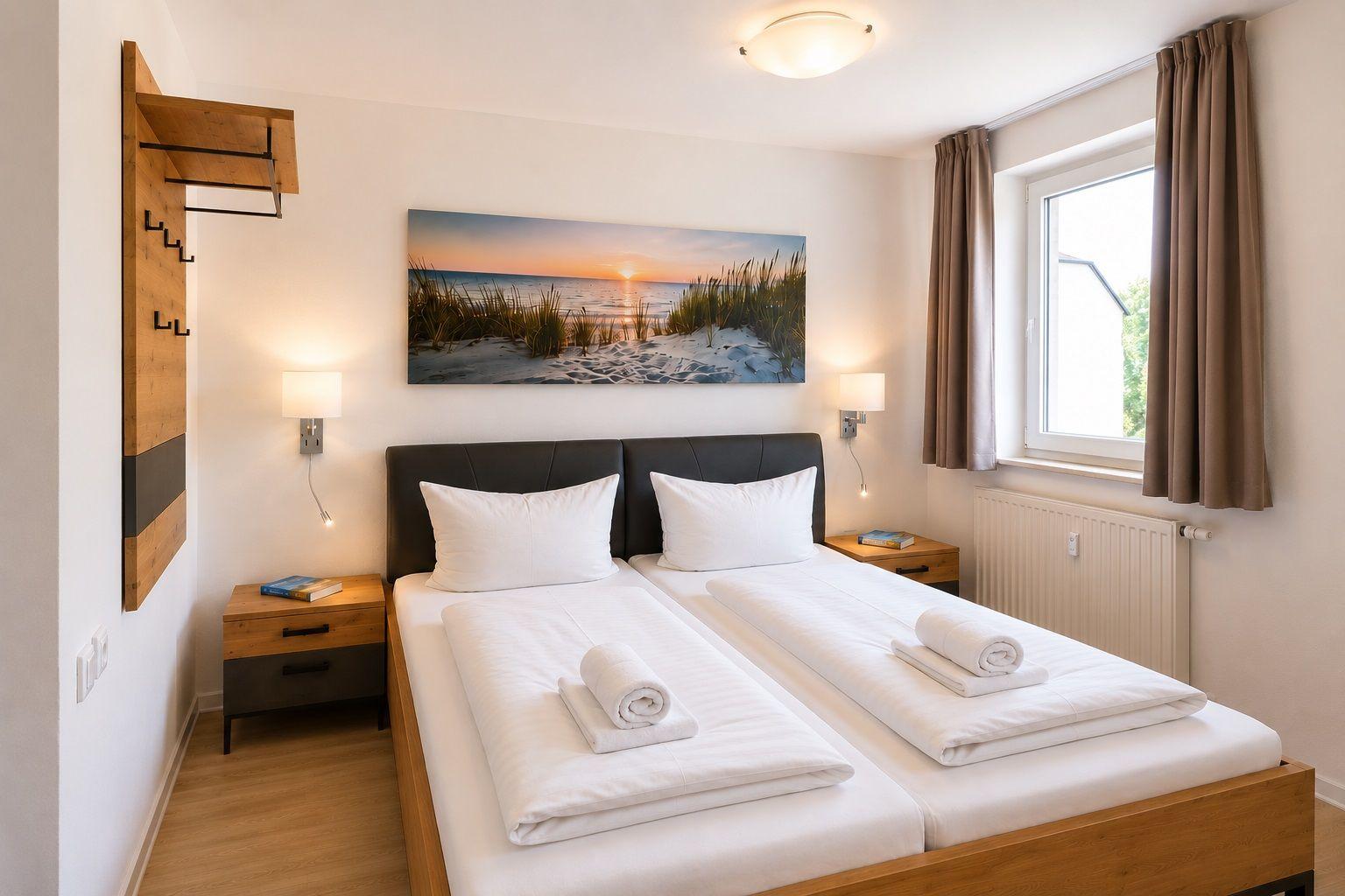 Zimmer mit Doppelbett, Wandbild und Fenster mit Vorhängen.