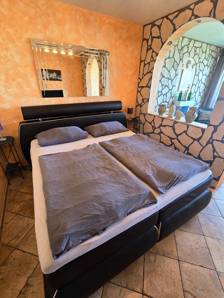 Komfortables Boxspringbett im Wohn-/Schlafraum für erholsame Nächte nahe Südstrand Fehmarn.