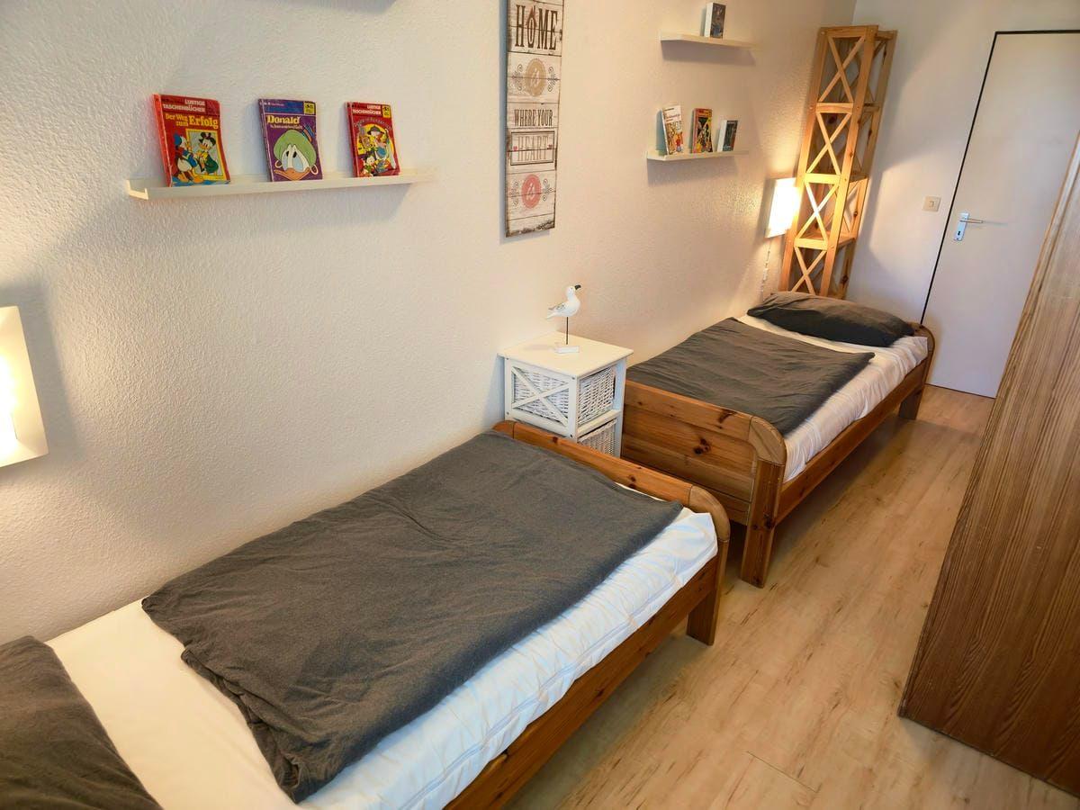 Freundliches separates Schlafzimmer mit gemütlichen Einzelbetten für entspannten Familienurlaub auf Fehmarn.