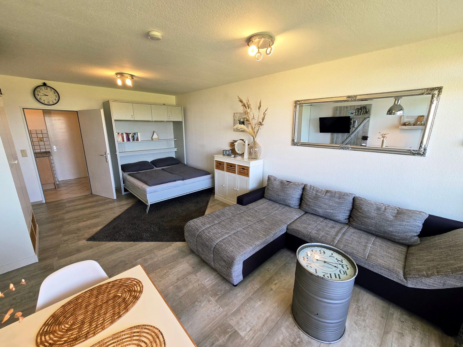 Gemütliches Wohn-/Schlafzimmer mit Sofalandschaft und heller Einrichtung für erholsame Urlaubstage.