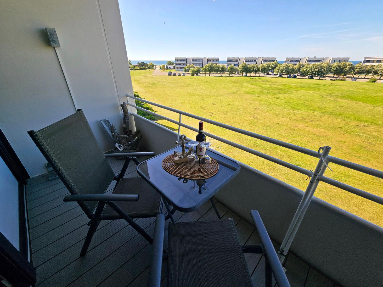 Gemütlicher Balkon mit Blick ins Grüne und Ostseeblick in der Ferne – ideal für entspannte Urlaubsmomente auf Fehmarn.