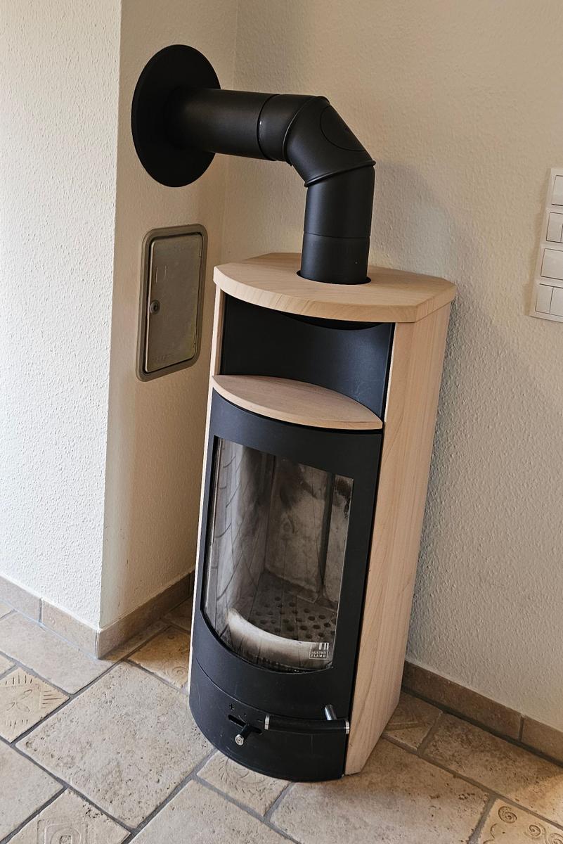 Kaminofen mit Holzofen und Schornstein in Ecke
