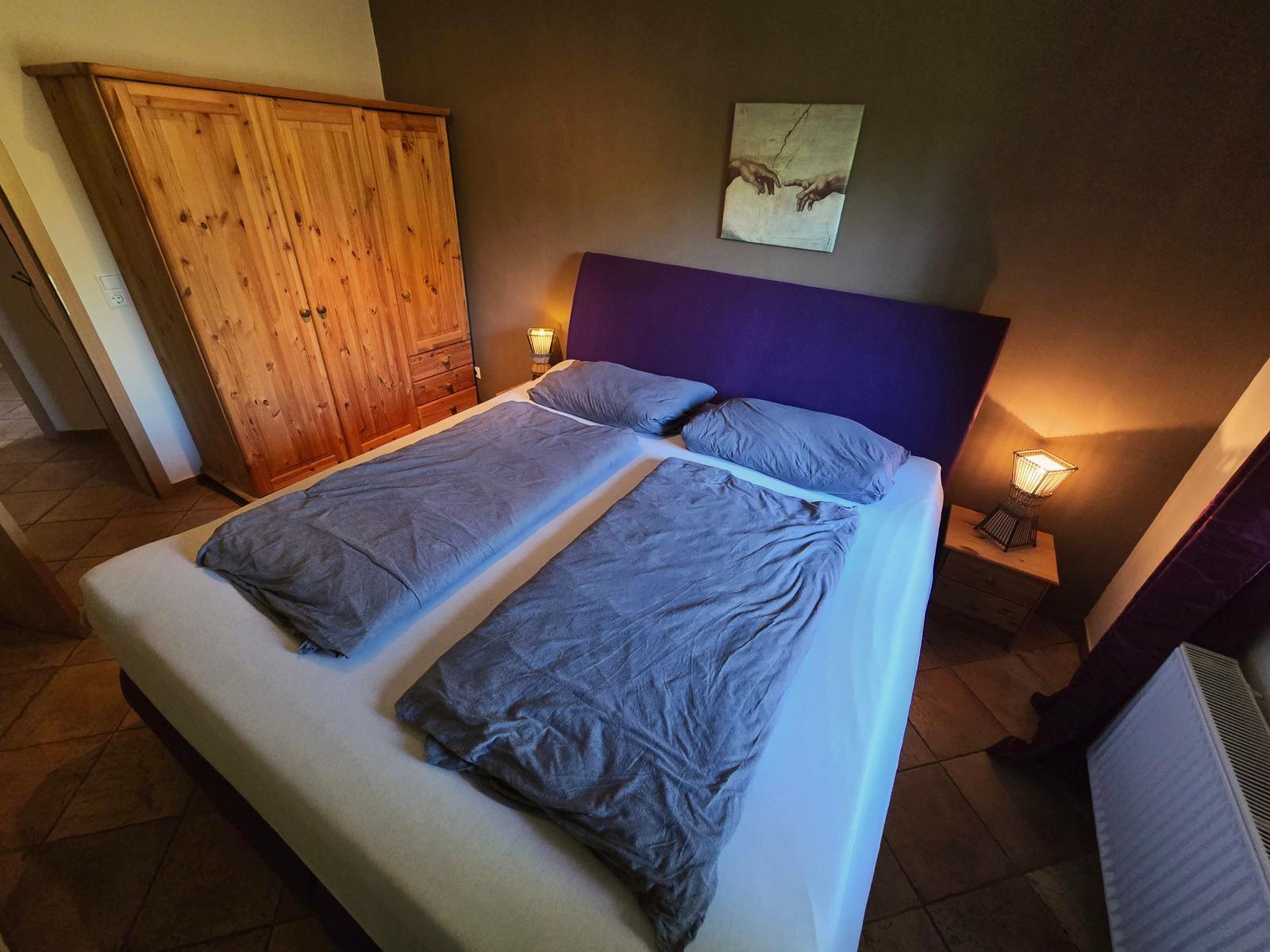 Gemütliches sep. Schlafzimmer mit Boxspringbett für erholsame Nächte im Urlaub auf Fehmarn.