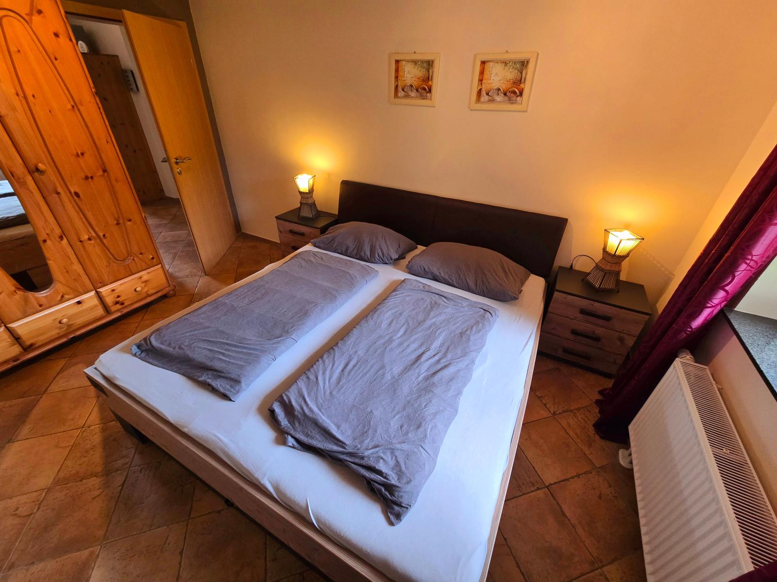 Helles sep. Schlafzimmer mit komfortablem Doppelbett und angenehmer Wohlfühlatmosphäre.