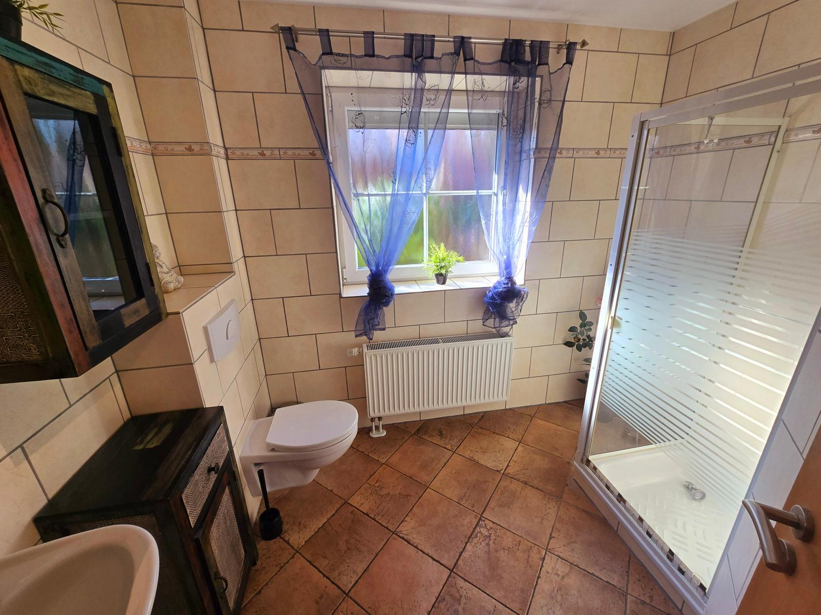 Geräumiges Badezimmer mit Dusche, Tageslicht und komfortabler Ausstattung für Ihren Urlaub.