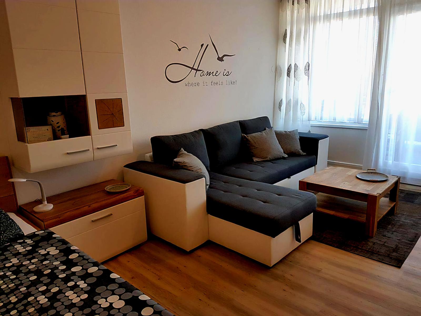 Gemütlicher Wohnbereich mit Sofa, TV und heller Wohlfühlatmosphäre für entspannte Urlaubstage.