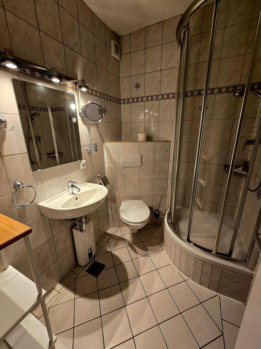 Funktional ausgestattetes Badezimmer mit Dusche, WC und Waschbecken für zusätzlichen Urlaubskomfort.