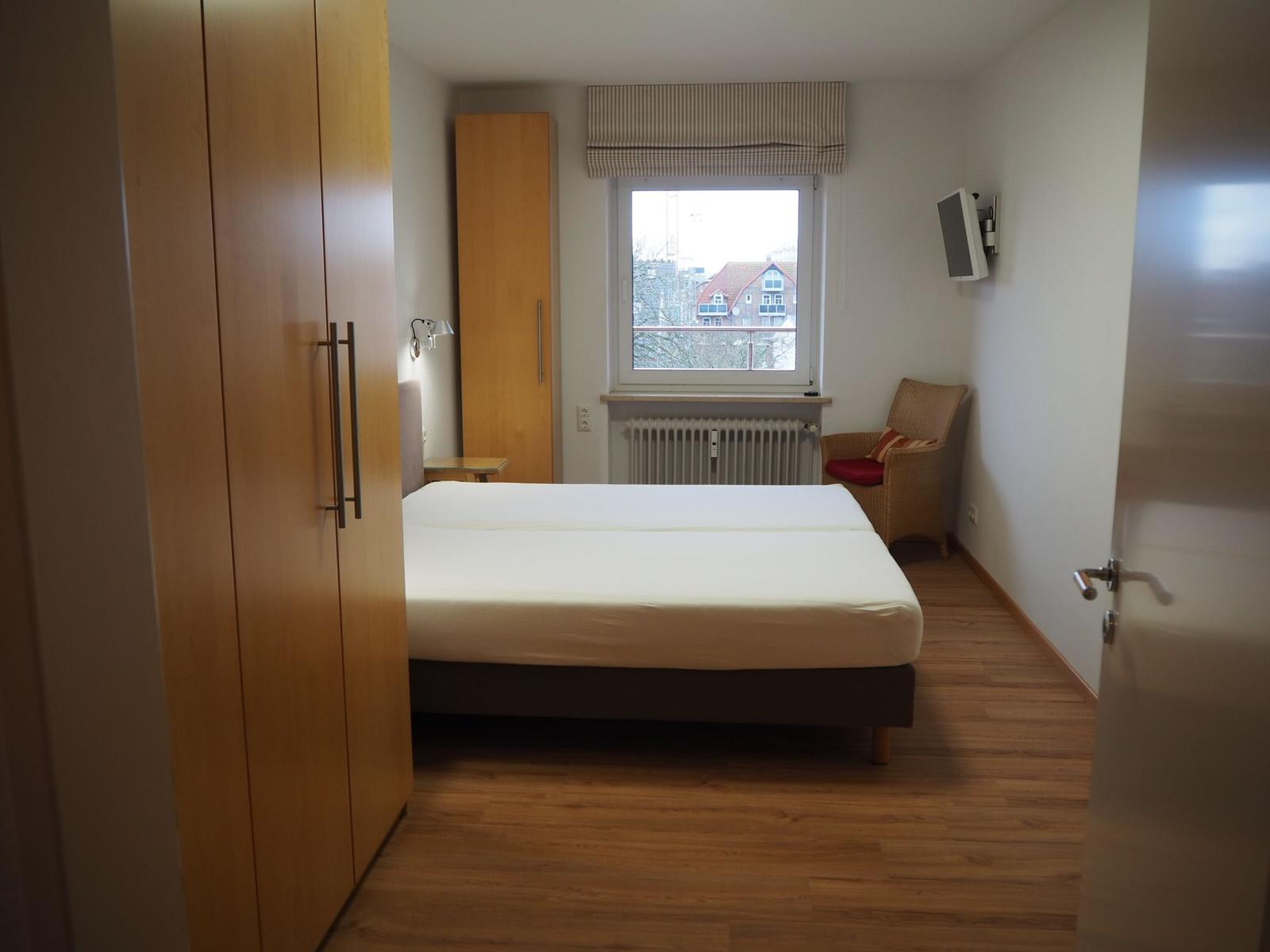 Schlafzimmer mit Doppelbett und TV