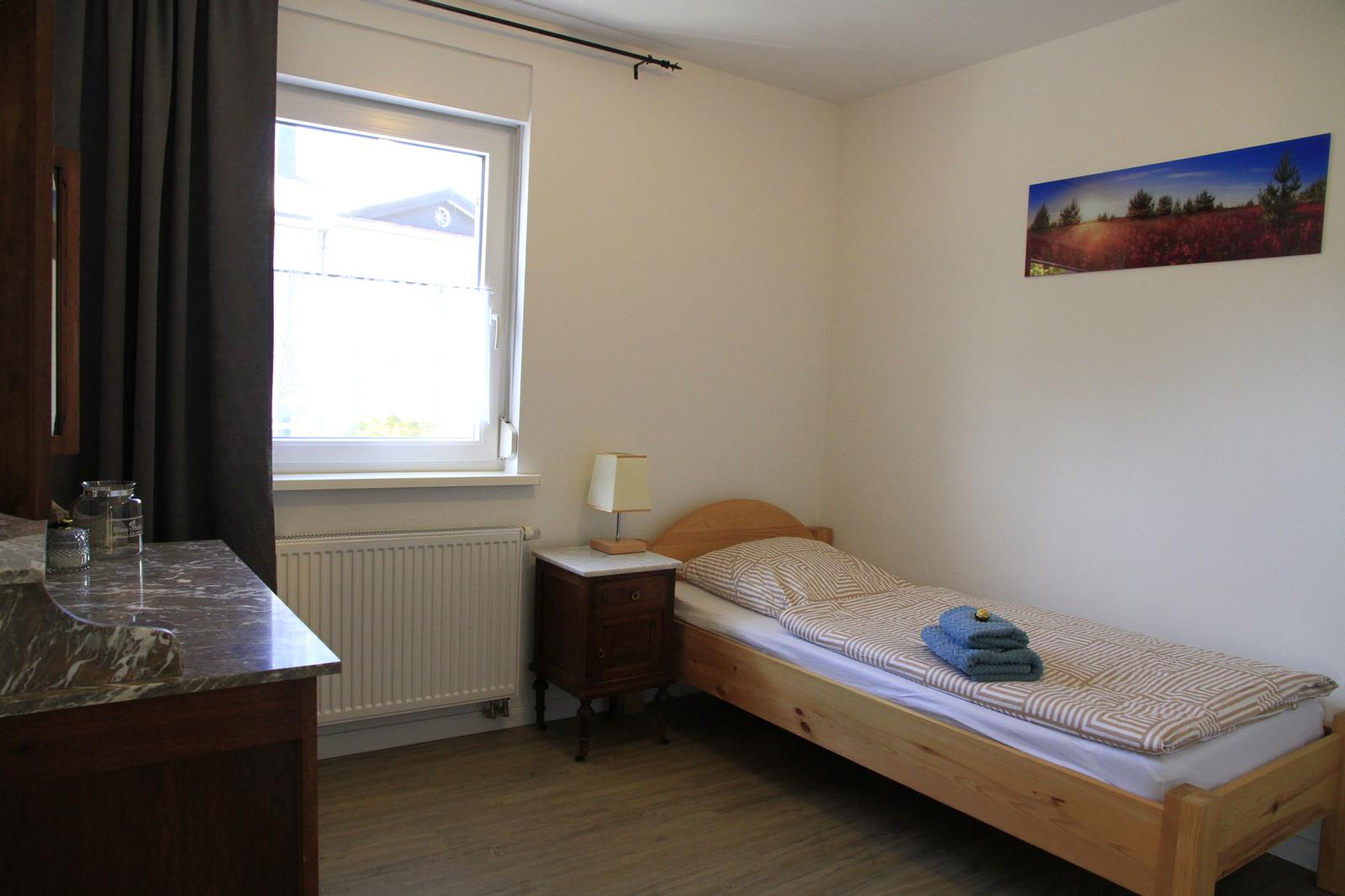 3. Schlafzimmer mit Einzelbett und Komode, sowie Fliegengitter