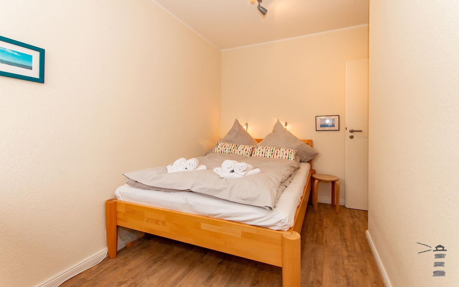 Ein Schlafzimmer mit einem Bett, einem Holzstuhl und einer Tür.