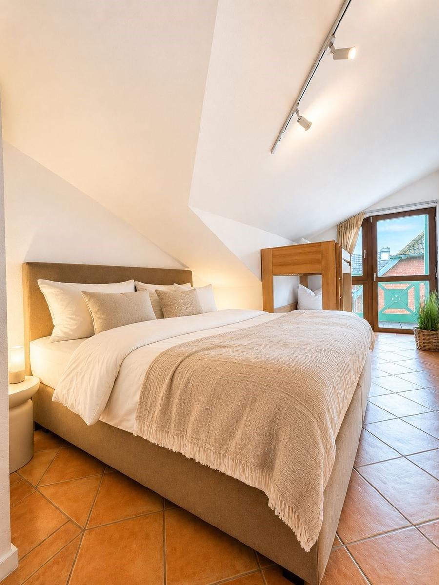 Schlafzimmer mit Doppelbett, Holzbett und Terrassentür.