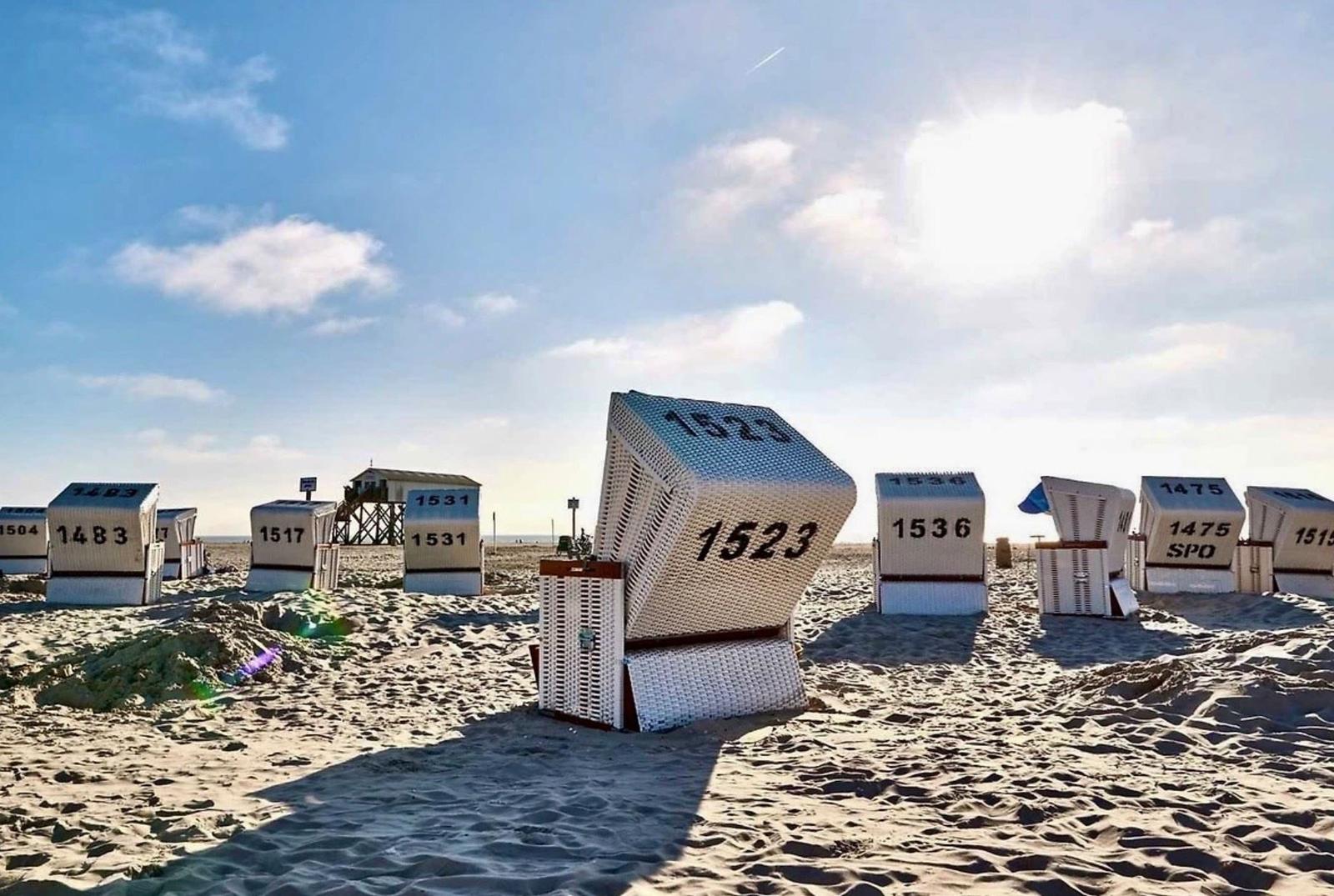 Strand mit traditionellen Strandkörben, einige stehend, einer umgekippt.