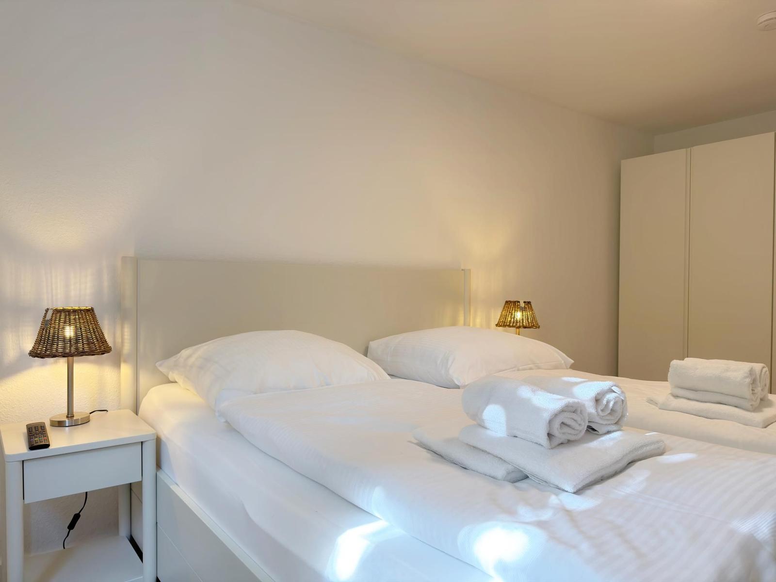 Schlafzimmer mit Doppelbett, zwei Nachttischen und einem Kleiderschrank.