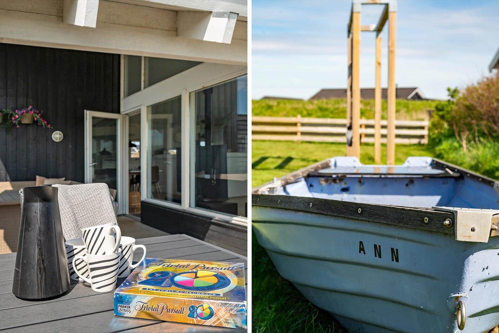 Deck with table, mugs, and Trivial Pursuit. Boat named ANN in grass.