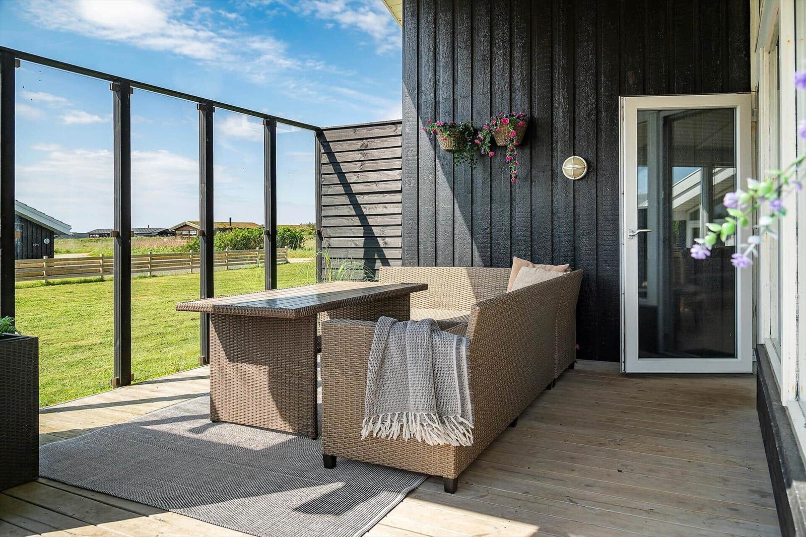Terrace with seating, table, and view of green area