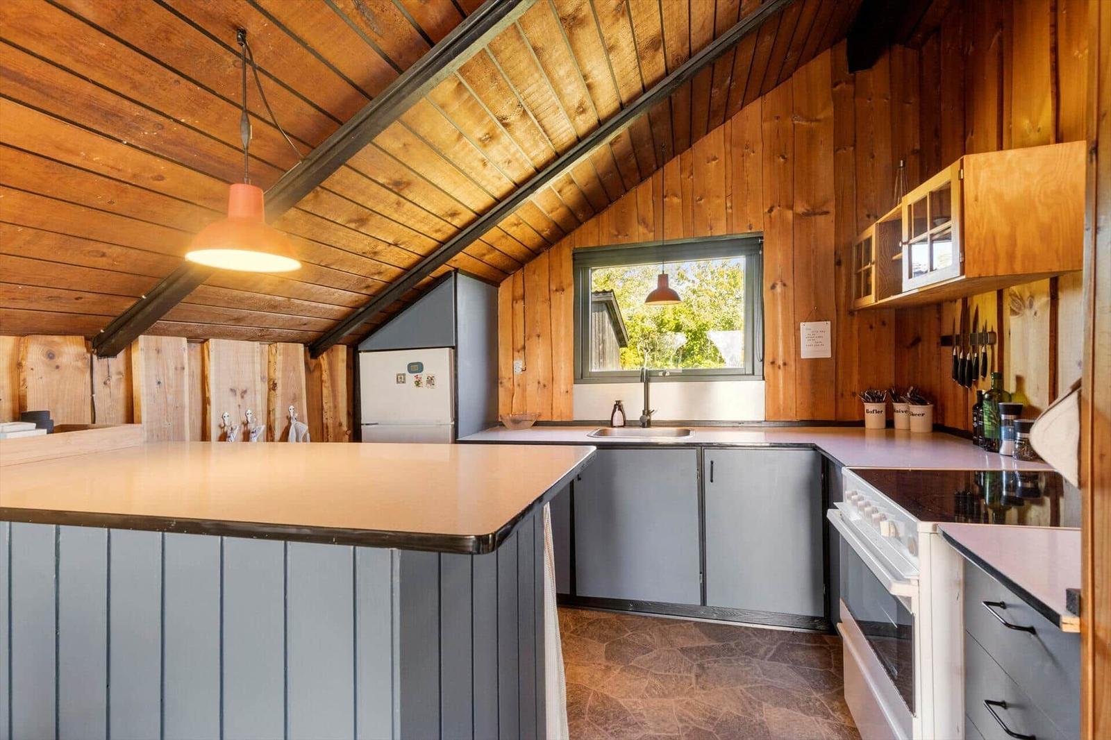 Kitchen with wooden walls, countertop, and window