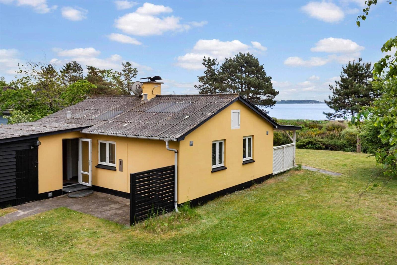 Gelbes Haus mit Garten und Blick auf Wasser