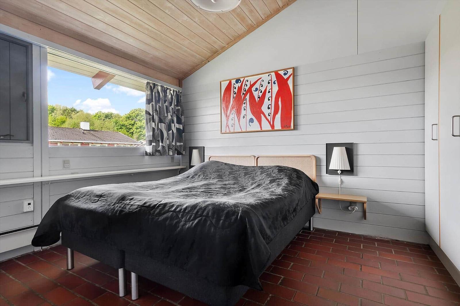 Bedroom with bed, window, and wall art.