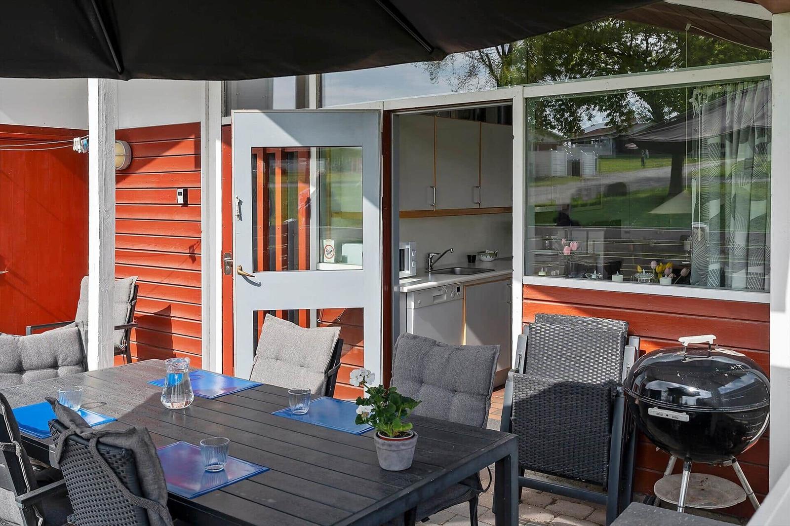 Terrace with table, chairs, and grill. Entrance to kitchen area.