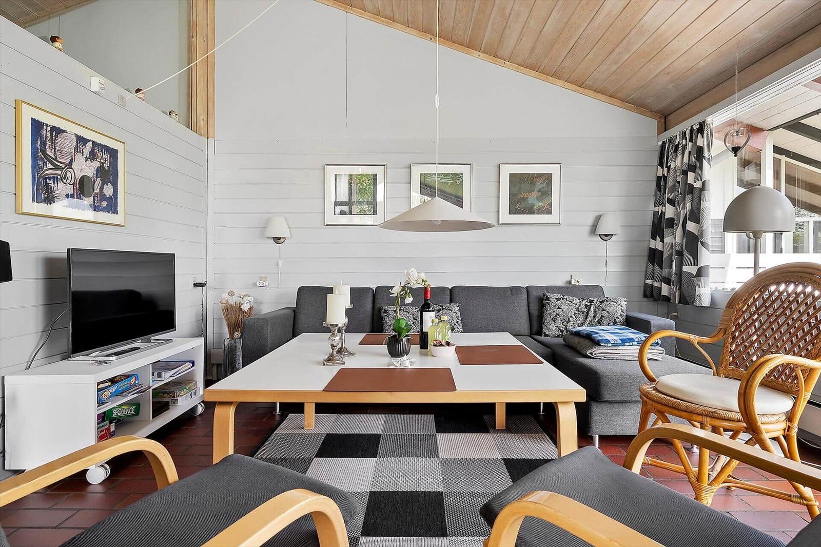 Living room with sofa, table, TV, and window