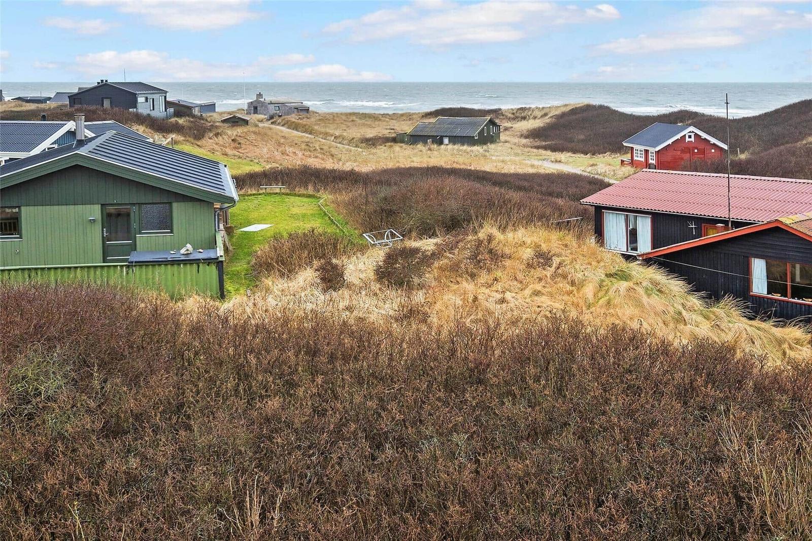 Strandnahe Häuser auf Dünen mit Blick auf das Meer.