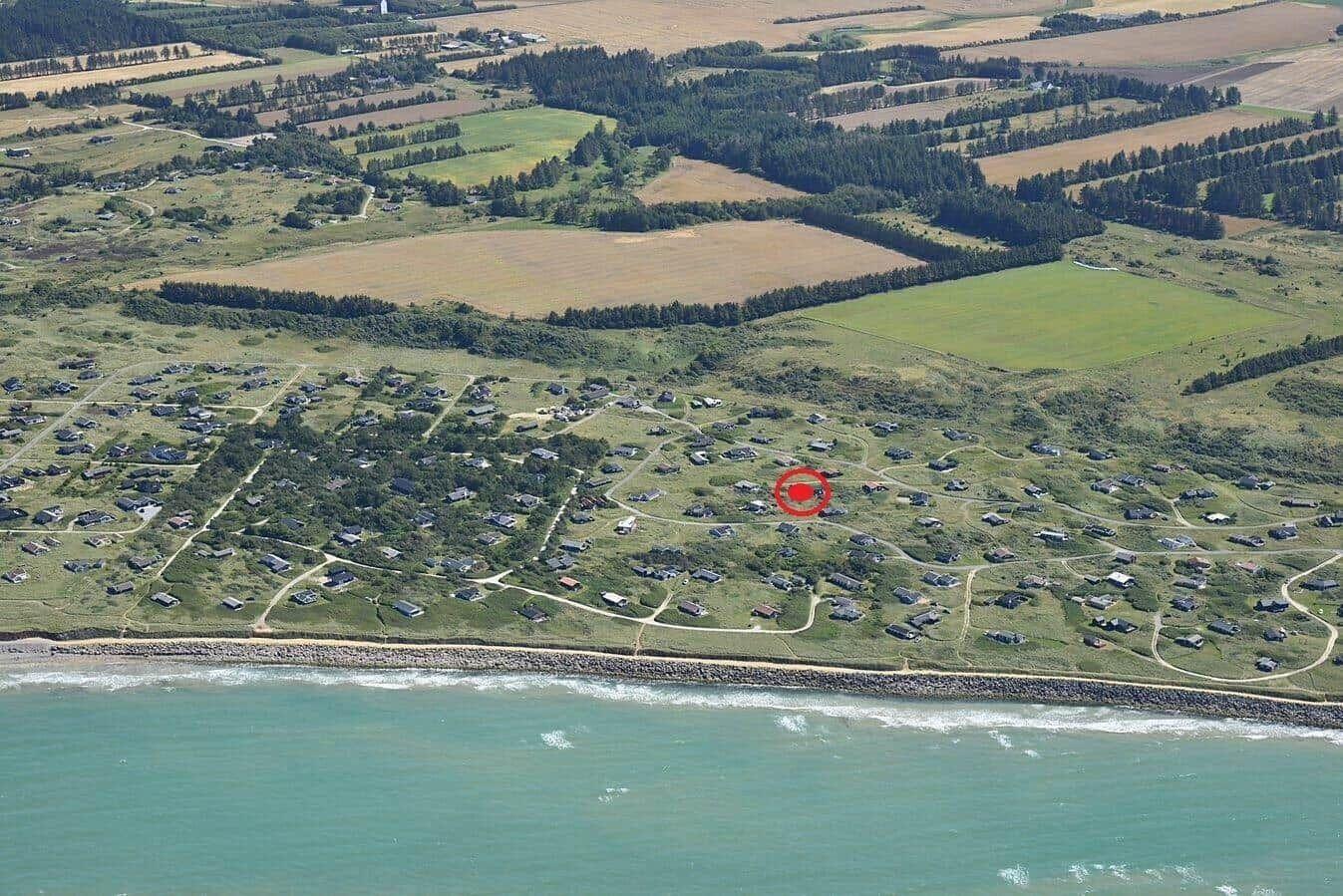 Aeriale Aufnahme einer Küstenlandschaft mit Wohnhäusern und Feldern.