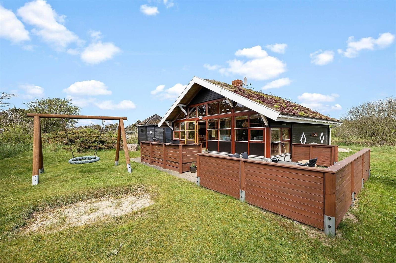 Haus mit Dachboden, Holzterrasse und Schaukel im Gras
