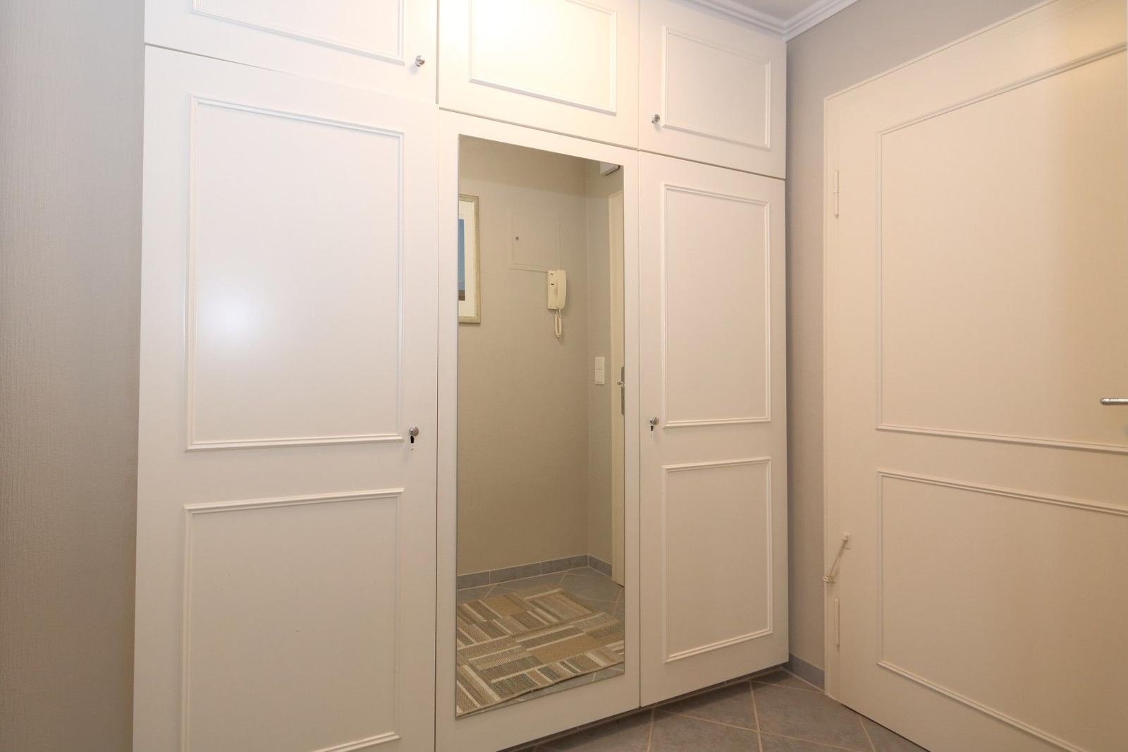 Back entrance with white doors and a mirrored panel.