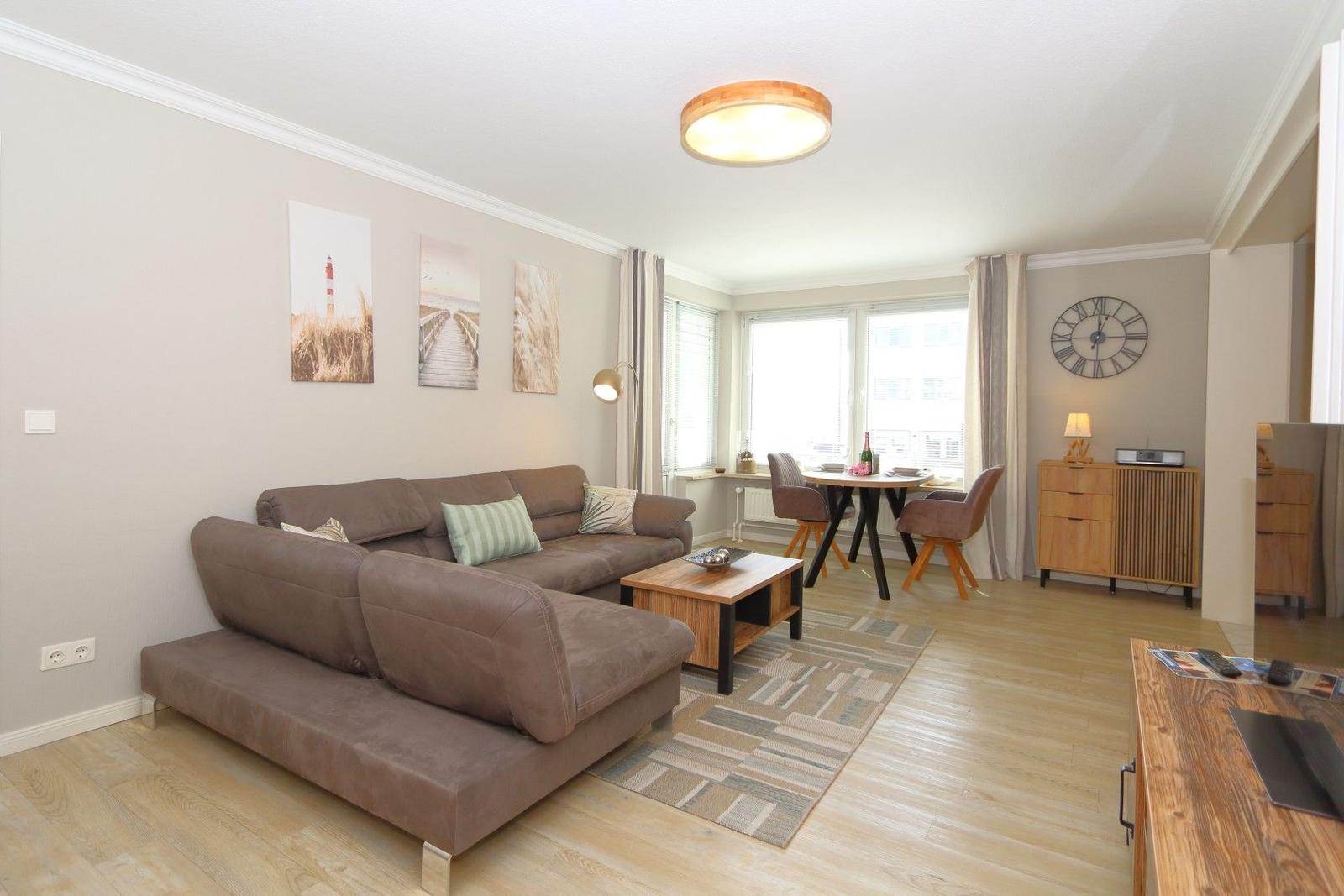 Living room with sofa, dining table, and wooden floor