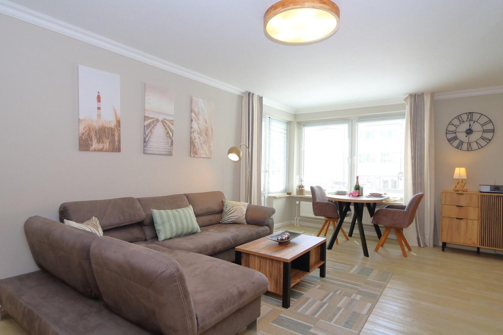 Living room with sofa, dining table, and wall art