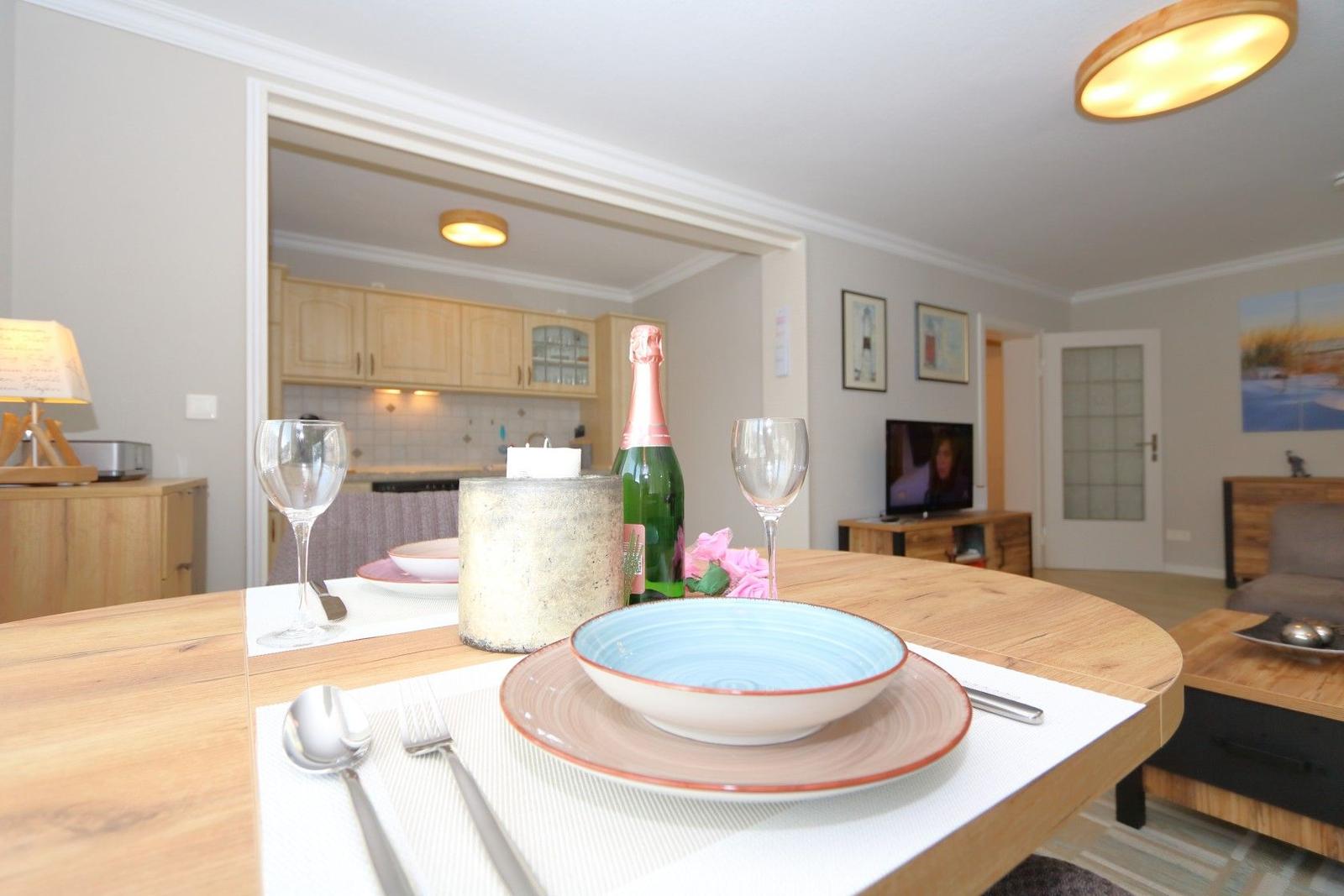 Dining table with dishes and a champagne bottle in the living area