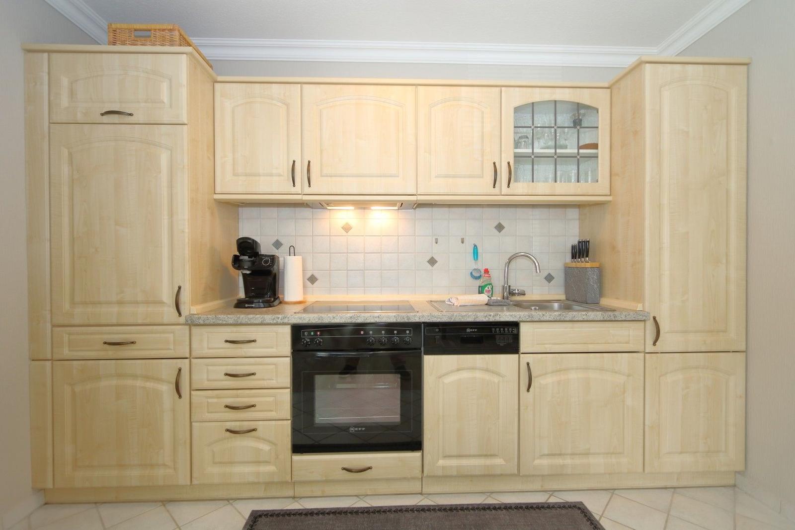 Kitchen with light cabinets, sink, stove, and oven.