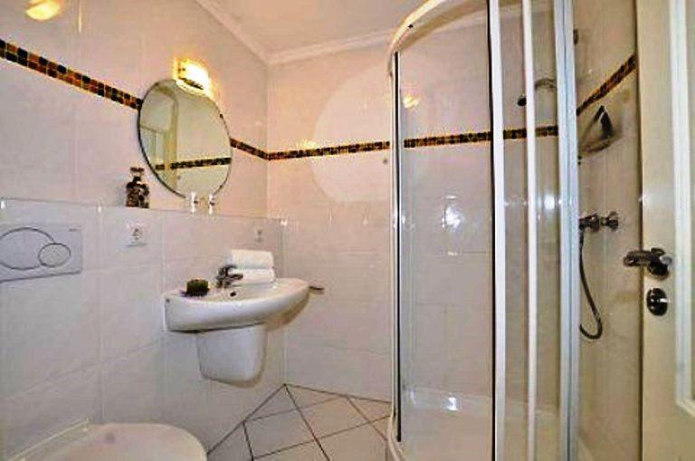 Badezimmer mit Dusche, Waschbecken und Toilette