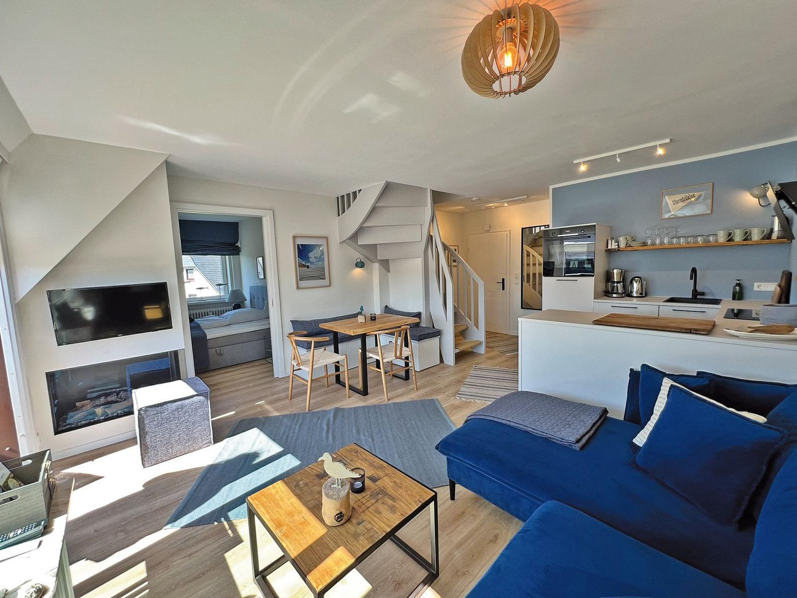 Wohnung mit Küche, Wohnbereich, Schlafzimmer und Treppe.