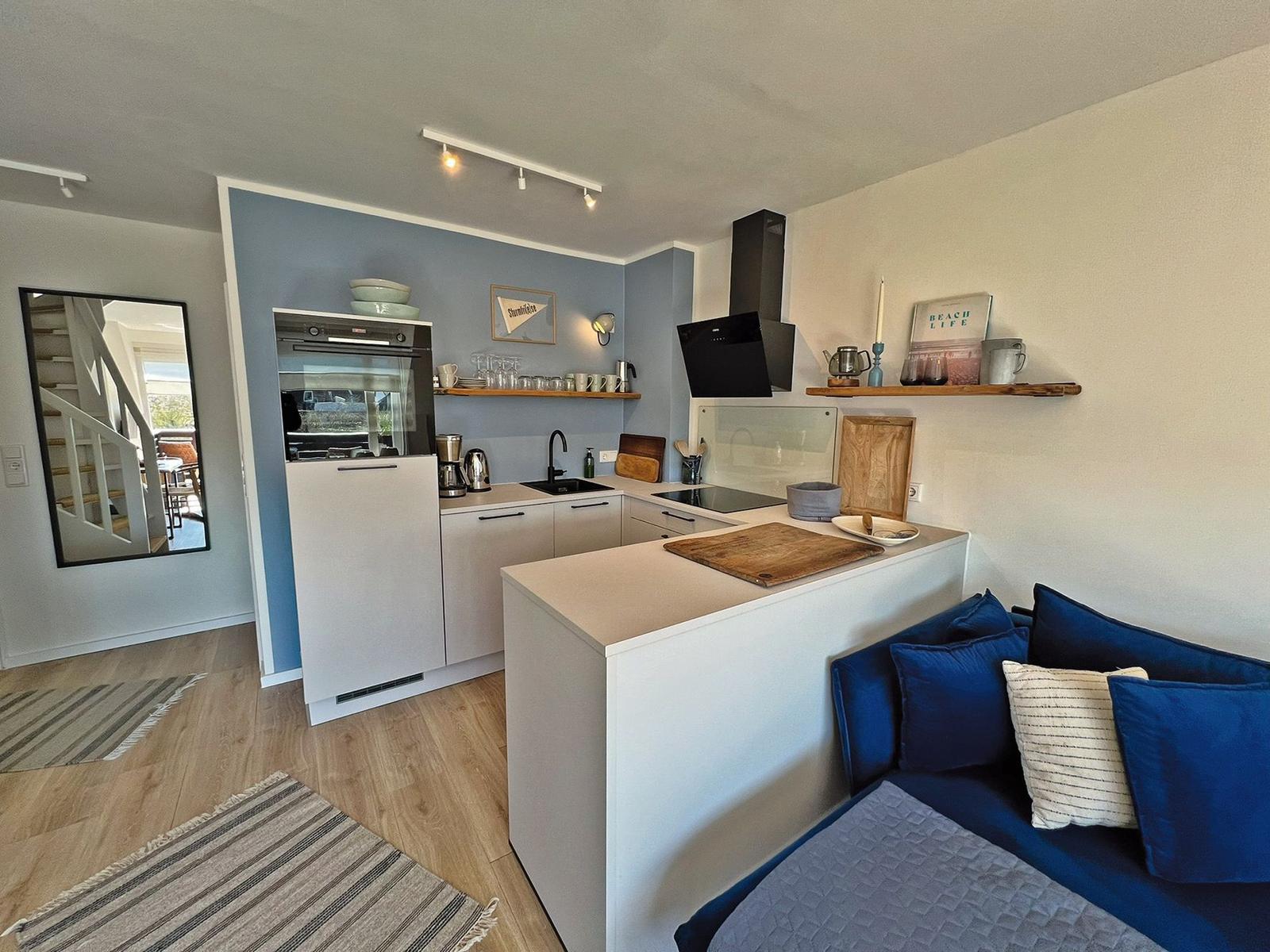 Küche mit Arbeitsplatte und Sofa im Vordergrund.