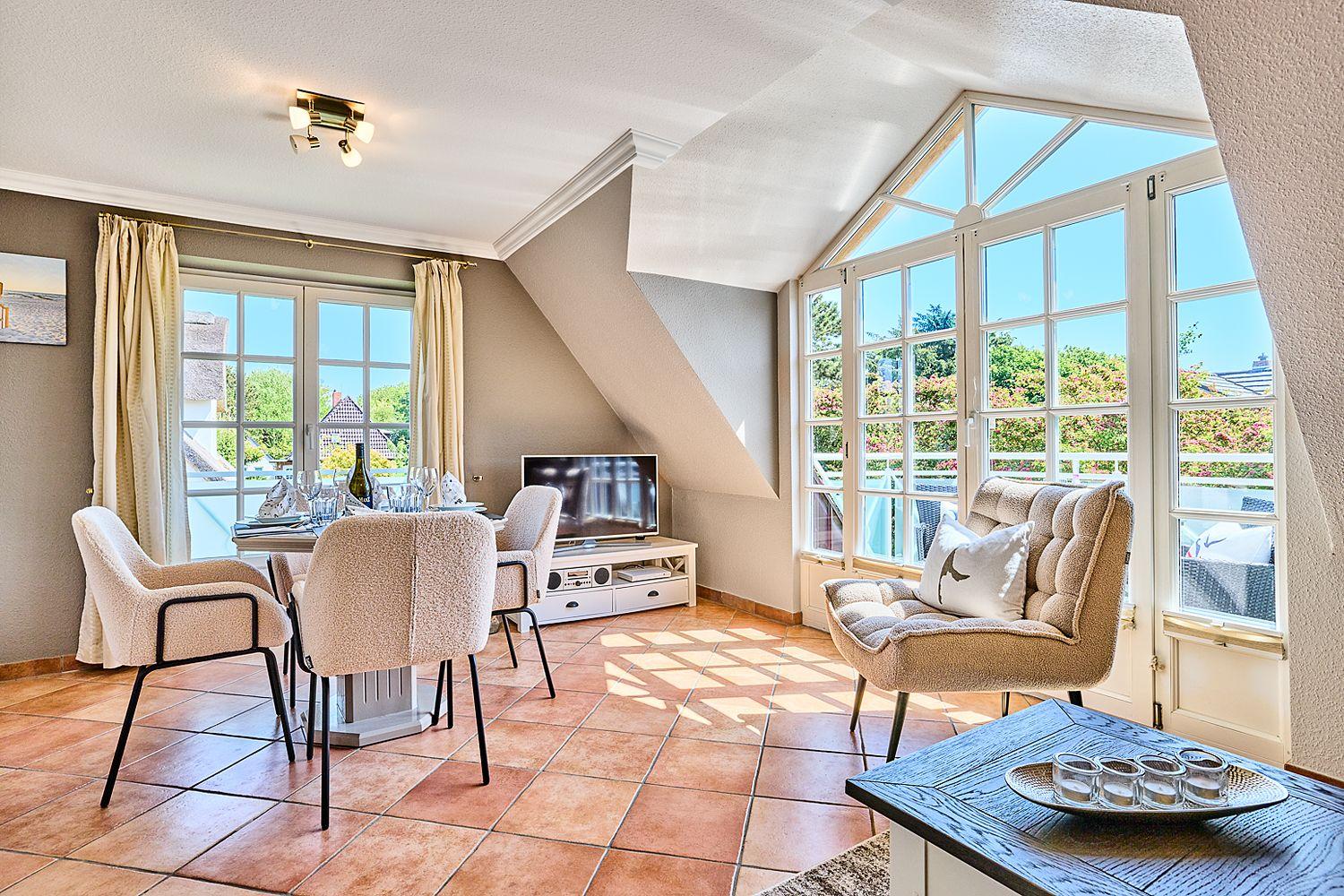 Wohn- und Essbereich mit großem Fenster, Esstisch und Sofa.