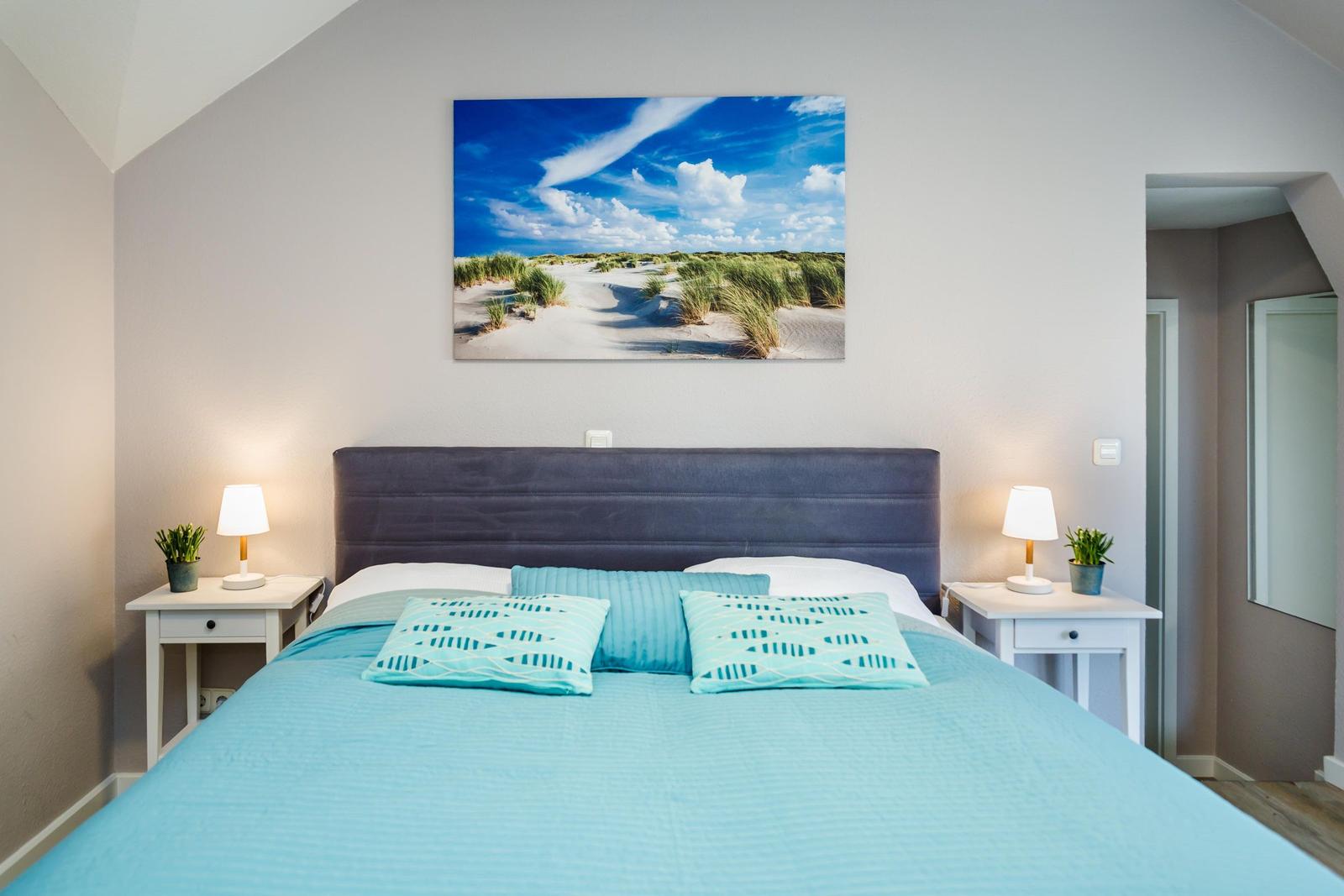Schlafzimmer mit Bett, Nachttischen und Wandbild