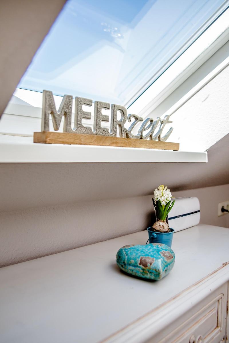 Skylight with MEERZeit decor, flower in cup, stone on cabinet
